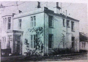 discolored black and white photo of two story house.